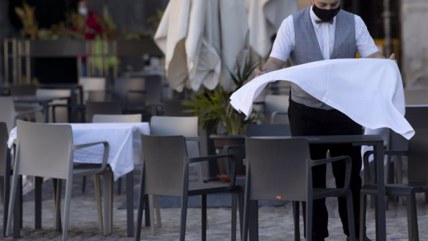 ep un camarero prepara la mesa de una terraza de un establecimiento