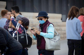 ep una mujer utiliza su movil en zonas cercanas a la sagrada familia protegida con mascarilla ante