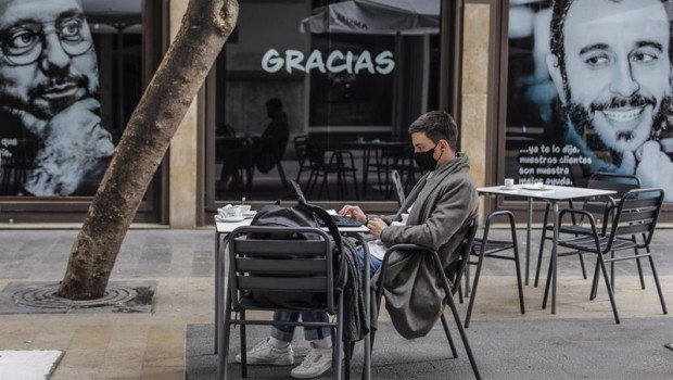 ep archivo   un joven trabaja con su ordenador portatil en una terraza el primer dia de la apertura