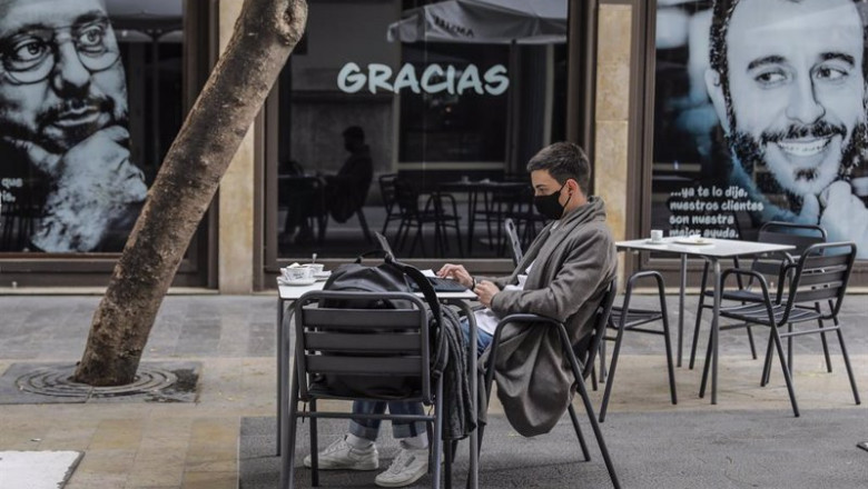 ep archivo   un joven trabaja con su ordenador portatil en una terraza el primer dia de la apertura