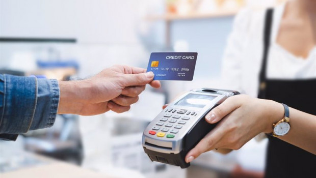 ep una persona pagando con tarjeta de credito en un datafono de un comercio