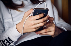 ep una adolescente mira la pantalla de su telefono movil