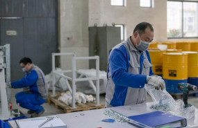 ep operarios de una fabrica protegidos con mascarillas y guantes