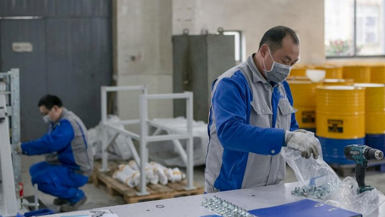 ep operarios de una fabrica protegidos con mascarillas y guantes