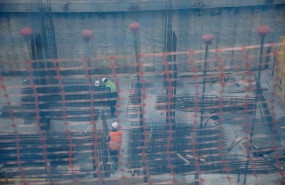 ep vista de dos obreros trabajando en el forjado de una obra a traves de una red de seguridad en