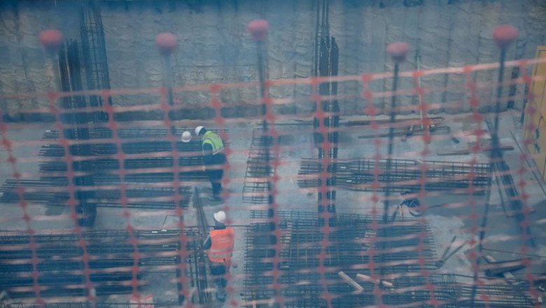ep vista de dos obreros trabajando en el forjado de una obra a traves de una red de seguridad en