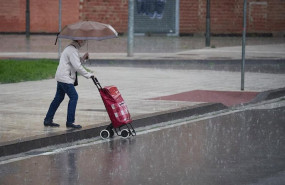 ep una mujer regresa de hacer la compra en plena lluvia durante el estado de alarma decretado por el