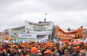 ep varios manifestantes con gorras naranjas y pancartas en defensa de la caza en la marcha 20m a 20