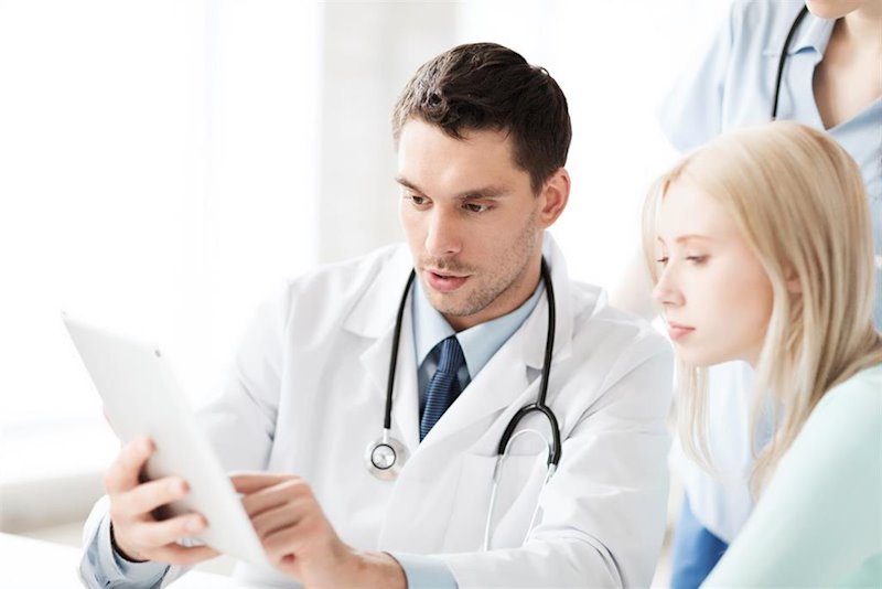 ep consulta medico medico muestra una tablet a una paciente asistencia sanitaria