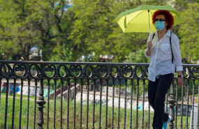 ep mujer pasea con un paraguas amarillo por el puente de triana cuando el termometro a alcanzado los
