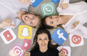 joven amigo sonriente acostado piso logotipos redes sociales que muestran signo thumbup 2 