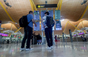 ep dos personas observan el panel de salidas con motivo de la operacion salida del puente de agosto