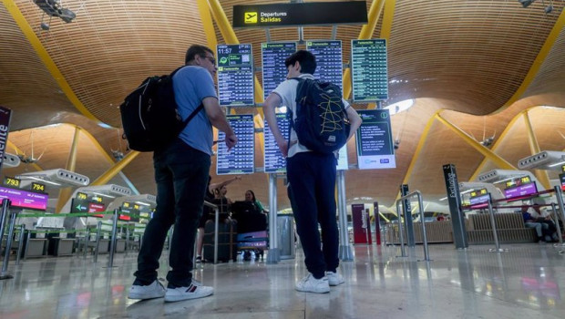 ep dos personas observan el panel de salidas con motivo de la operacion salida del puente de agosto