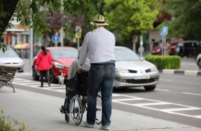 ep un hombre pasea a una persona de edad avanzada en silla de ruedas durante su franja horaria