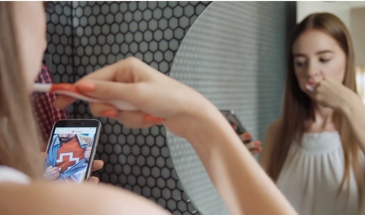 ep una joven consulta la app de cruz roja de voluntariado mientras se cepilla los dientes