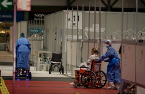 ep dos sanitarios trabajan trasladando pacientes en silla de ruedas en el pabellon 9 del hospital de