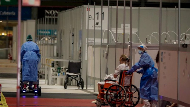 ep dos sanitarios trabajan trasladando pacientes en silla de ruedas en el pabellon 9 del hospital de