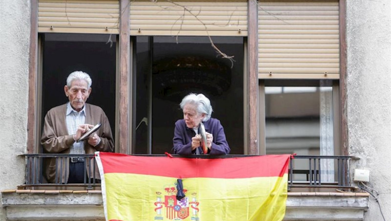 ep un hombre y una mujer asomados a su balcon hacen sonar tapas de cacerolas durante la cacerolada ep un hombre y una mujer asomados a su balcon hacen sonar tapas de cacerolas durante la cacerolada