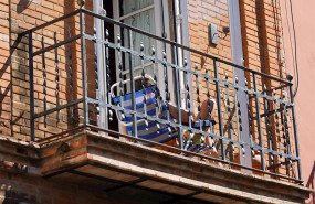 ep un joven aprovecha su minusculo balcon para tomar el sol en la tercera semana de confinamiento