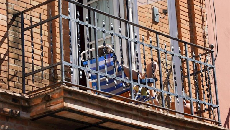 Un joven aprovecha su minúsculo balcón para tomar el sol en la tercera semana de confinamiento por el coronavirus COVID 19. Sevilla a 03 de abril del 2020 | Eduardo Briones - Europa Press ep un joven aprovecha su minusculo balcon para tomar el sol en la tercera semana de confinamiento