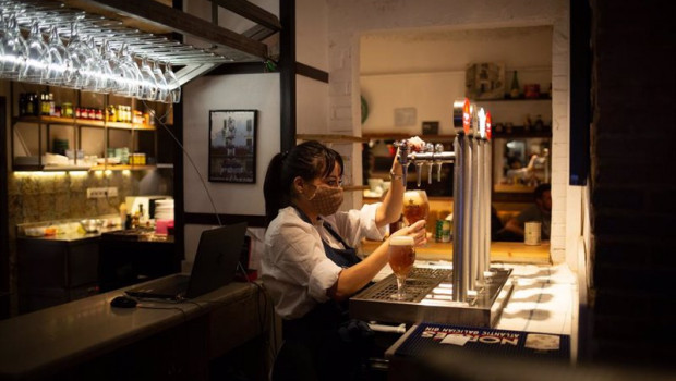 ep una camarera sirve una cerveza en el interior de un bar de barcelona