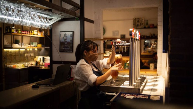 ep una camarera sirve una cerveza en el interior de un bar de barcelona
