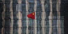 chinese national flag flutters at the headquarters of a commercial bank on a financial street near the headquarters of the people s bank of china china s central bank in central beijing 