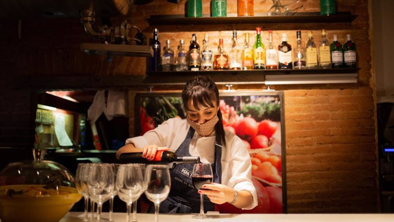 ep archivo   una camarera sirve una copa de vino en el interior de un bar