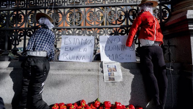 ep dos espantapajaros junto a dos carteles en los que se leen estamos en la ruina no aguantamos mas