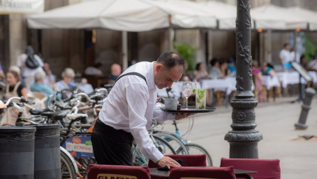 ep archivo   un camarero limpia una mesa en la plaza real de barcelona