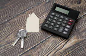 paper cut out house with keys calculator wooden textured surface 