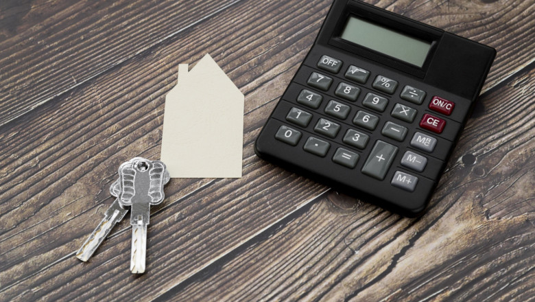 paper cut out house with keys calculator wooden textured surface 